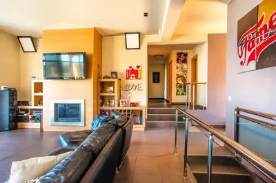 a living room with a leather couch and a tv at Luxury 6-Bedroom Villa With Private Pool- Villa Prigipessa in Chania Town