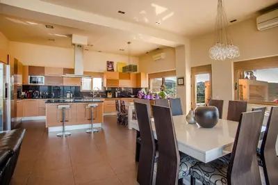 a kitchen with a table and some chairs and a counter at Luxury 6-Bedroom Villa With Private Pool- Villa Prigipessa in Chania Town