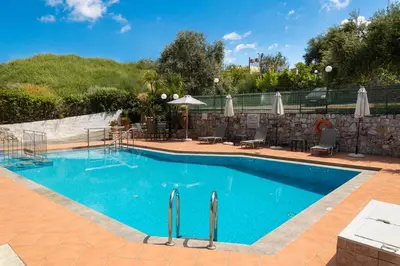 a large swimming pool with blue water at Aphrodite Apartments in Kalyves