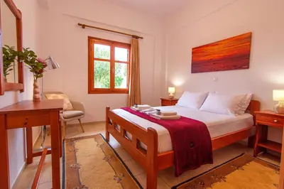 a bedroom with a bed and a desk and a window at Liviko Beach Apartments - only adults in Frangokastello