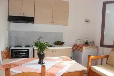 a kitchen with a table with a vase on it at Maria's Apartments in Kalyves