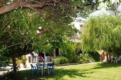 a table and chairs under a tree in a yard at Maria's Apartments in Kalyves