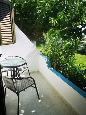 a table and a chair sitting on a patio at Orthi Ammos in Frangokastello