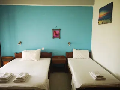 two beds in a room with blue walls at Orthi Ammos in Frangokastello