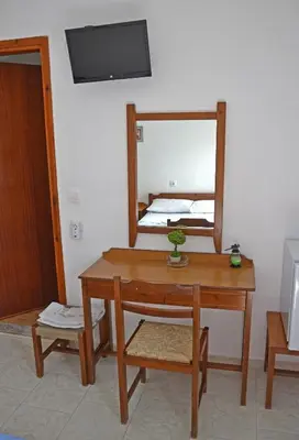 a room with a table and a mirror and a bed at Orthi Ammos in Frangokastello