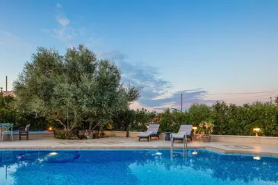 a swimming pool with two chairs and a table at Villa Nikis in Chania Town