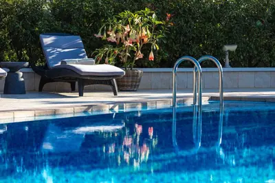 a swimming pool with a chair at Villa Nikis in Chania Town