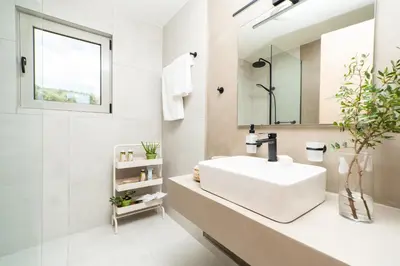 a white bathroom with a sink and a mirror at Villa Oliveto in Tavronitis