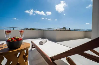 a balcony with a table and two glasses of wine at Villa Oliveto in Tavronitis