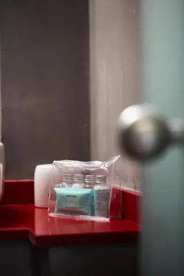 a red counter with a bottle of soap and a mirror at Chrissula apt Homeleader in Chania Town