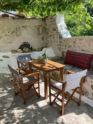 a wooden table and chairs with a table and a couch at Sergios Village House in Chania Town