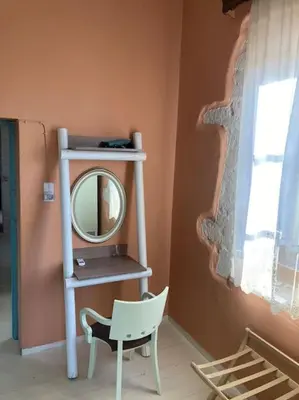 a room with a mirror and a chair and a shelf at Sergios Village House in Chania Town