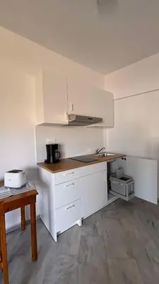 a kitchen with white cabinets and a counter top at Menelaos Apartments in Daratso