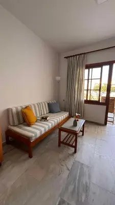 a living room with a couch and a table at Menelaos Apartments in Daratso