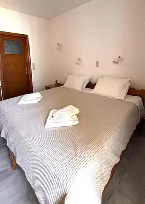 a large white bed with two towels on it at Menelaos Apartments in Daratso