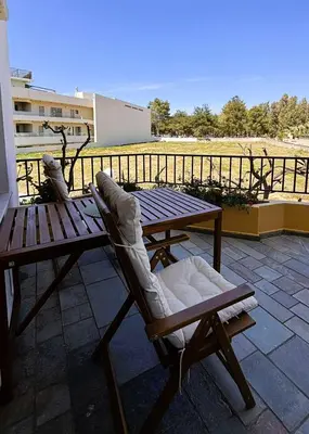 a wooden table and chairs sitting on a patio at Menelaos Apartments in Daratso