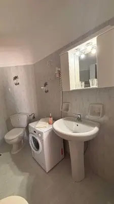 a bathroom with a sink and a washing machine at Menelaos Apartments in Daratso