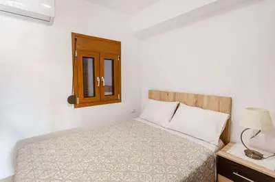 a small bedroom with a bed and a cabinet at Platania's Paradise in Chania Town