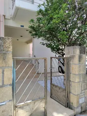 a metal gate with a tree in a building at Chania Sweet Apts in Chania Town