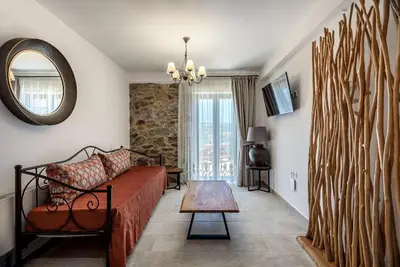 a living room with a couch and a mirror at Minos Country Living Apartments in Agrilés