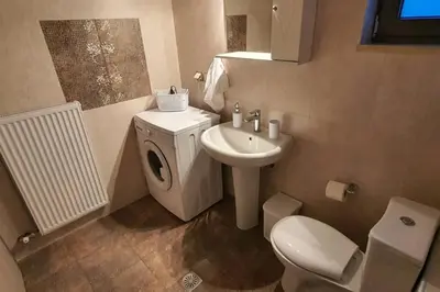a bathroom with a white toilet and a sink at Olivia in Chania Town