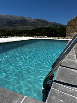 a pool of blue water with mountains in the background at Pulchra Campis,Private Pool,Wifi,Parking in Nerokoúros