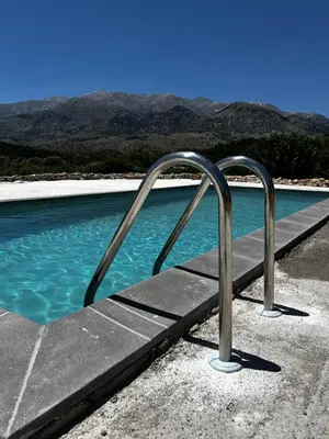 a pool of blue water with a metal hand rail at Pulchra Campis,Private Pool,Wifi,Parking in Nerokoúros