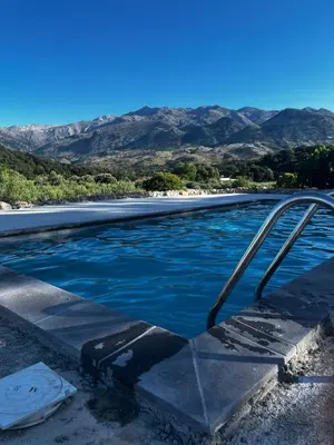 a pool of water with mountains in the background at Pulchra Campis,Private Pool,Wifi,Parking in Nerokoúros