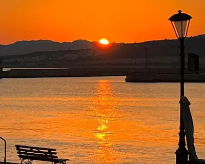 a bench and a street light with the sunset in the background at Casa Livieres in Chania Town