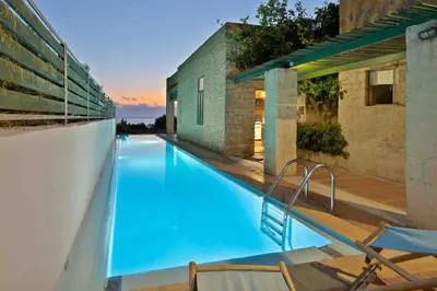 a swimming pool with chairs and a building at Villa Mediterranea - Heated Pool optional in Livadia