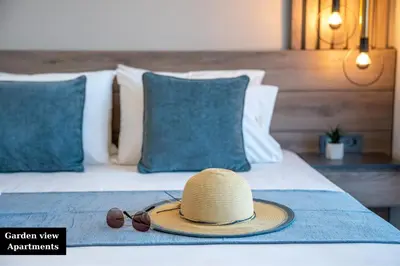 a straw hat and sunglasses sitting on a bed at Litinakis Studios Sea View & Litinakis Studios Garden View 700 meters away in Agia Marina Nea Kydonias