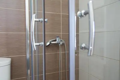 a shower with a glass door in a bathroom at Litinakis Studios Sea View & Litinakis Studios Garden View 700 meters away in Agia Marina Nea Kydonias
