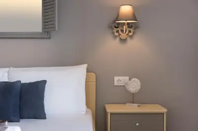 a bedroom with a bed and a lamp on a table at Wave rooms in Maleme