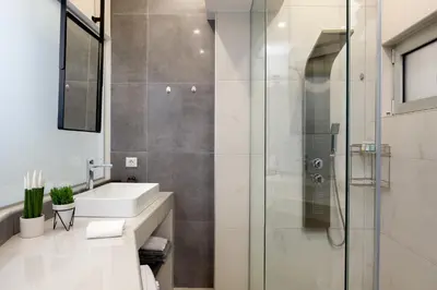 a bathroom with a sink and a shower at Just Creta Sea View apartment in Chania Town