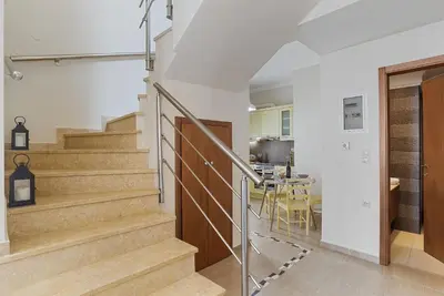 a staircase in a home with white walls and a kitchen at Amphitrite Beach House in Chania Town