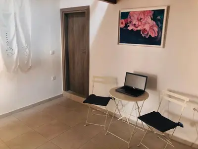 a room with a table with a laptop on it at House Gylisma in Kámbos