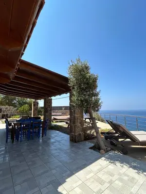 a patio with a table and chairs and the ocean at House Gylisma in Kámbos