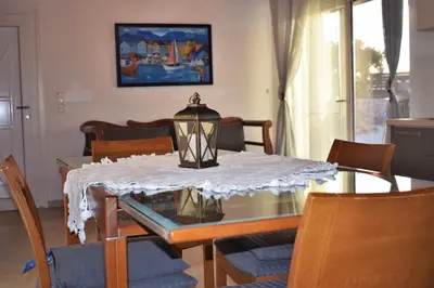 a dining room table with a white table cloth on it at House Gylisma in Kámbos