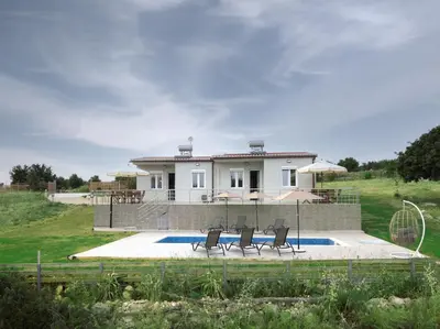 a house with a swimming pool and three chairs at RODOU Suites & Villas in Chania Town