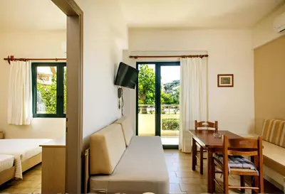 a living room with a bed and a table and a couch at Lili Apartments,oasis 2,5 km from Hania center in Parigoría