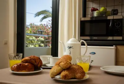 a table with two plates of pastries and orange juice at Lili Apartments,oasis 2,5 km from Hania center in Parigoría
