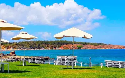 a group of chairs and umbrellas on a beach at Lili Apartments,oasis 2,5 km from Hania center in Parigoría