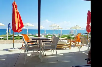 a patio with a table and chairs and umbrellas at Lili Apartments,oasis 2,5 km from Hania center in Parigoría