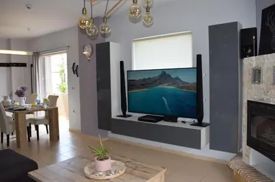 a living room with a flat screen tv on a wall at Elizabeth cozy home close to the beach in Chania Town