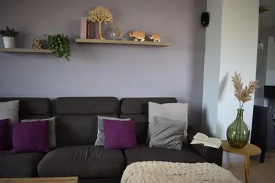 a living room with a gray couch with purple pillows at Elizabeth cozy home close to the beach in Chania Town