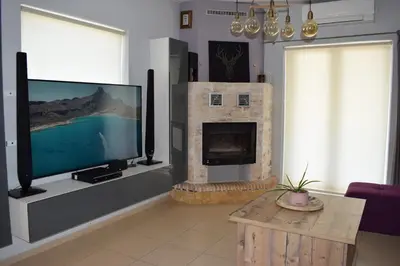 a living room with a tv and a fireplace at Elizabeth cozy home close to the beach in Chania Town