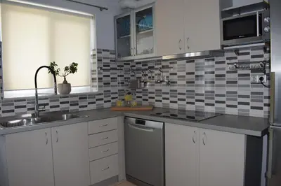 a kitchen with white cabinets and a sink at Elizabeth cozy home close to the beach in Chania Town
