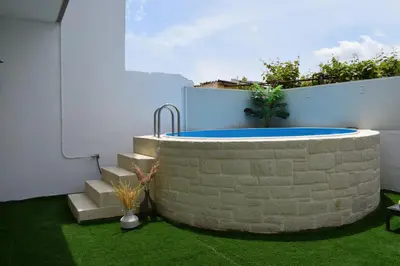 a circular pool in a yard with green grass at Elizabeth cozy home close to the beach in Chania Town