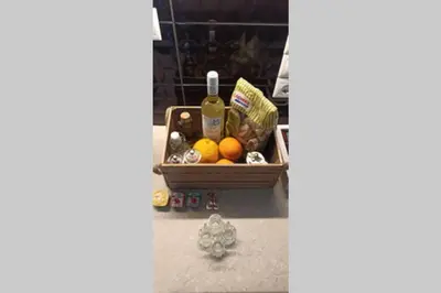 a basket filled with fruit and a bottle of wine at GS Lumen Apartment in Chania Town