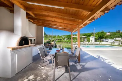 a patio with a table and chairs and a fireplace at MM Villa in Chania Town